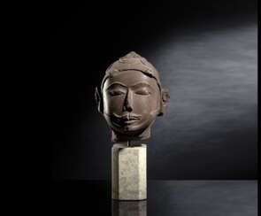 Kopf einer männlichen Gottheit aus rötlich-braunem Stein auf einen Sockel montiert