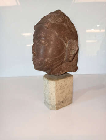 Kopf einer männlichen Gottheit aus rötlich-braunem Stein auf einen Sockel montiert - Foto 6