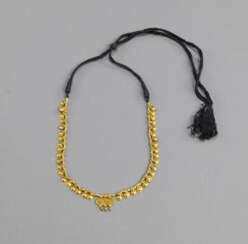 Feine Goldkette, mit zahlreichen scheibenförmige Kettengliedern in Reihung auf einem verstellbaren Flechtband aufgezogen.