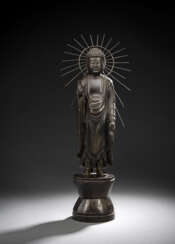 Bronze des Buddha Amida auf einem Lotus-Sockel vor einer strahlenförmigen Mandorla