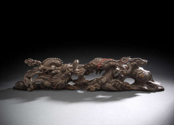 Zierleiste aus Holz mit geschnitztem Dekor eines sich windenden Drachens zwischen Gischt teils mit roter Farbe akzentuiert, die Augen mit Glas eingelegt - фото 1