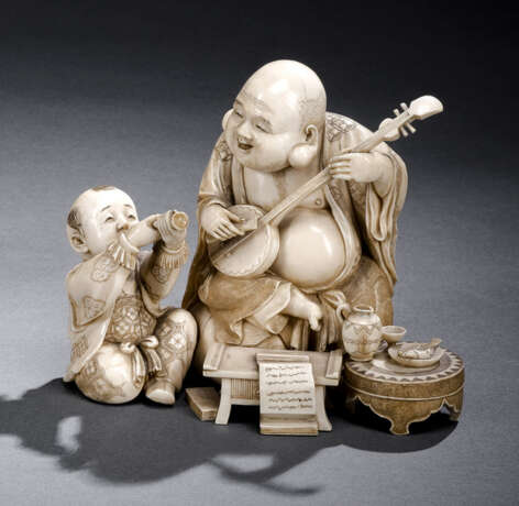 Feines Okimono aus Elfenbein mit Darstellung des musizierenden Hoteis nebst Trompete spielendem Karako - Foto 1