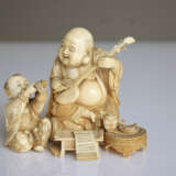 Feines Okimono aus Elfenbein mit Darstellung des musizierenden Hoteis nebst Trompete spielendem Karako - Foto 2