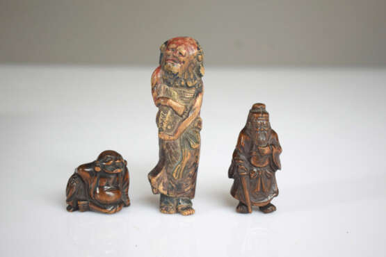 Vier Netsuke aus Holz: Hotei, Kwanju, Maske der Okame und Sennin mit Resten von polychromer Fassung - Foto 2