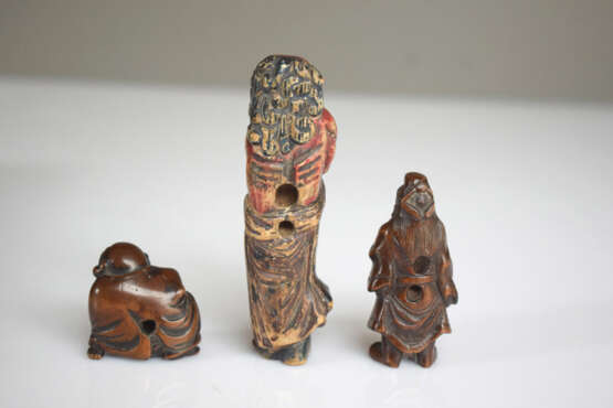 Vier Netsuke aus Holz: Hotei, Kwanju, Maske der Okame und Sennin mit Resten von polychromer Fassung - Foto 3