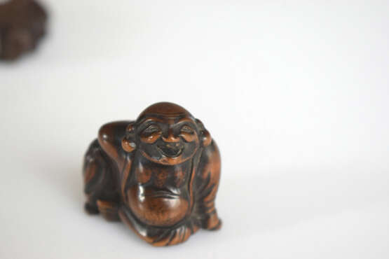 Vier Netsuke aus Holz: Hotei, Kwanju, Maske der Okame und Sennin mit Resten von polychromer Fassung - Foto 5