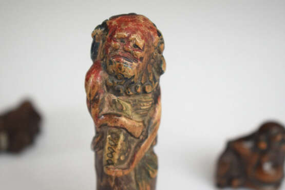 Vier Netsuke aus Holz: Hotei, Kwanju, Maske der Okame und Sennin mit Resten von polychromer Fassung - photo 6