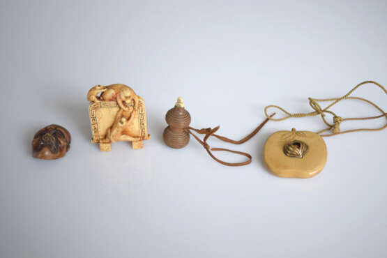 Vier Netsuke und Okimono aus Elfenbein bzw. Holz: Manju in Form eines Pfirsichs mit Gold-und Koralleinlage, Stellschirm mit drei spielenden Affen, Maske und kleine Flasche - Foto 2