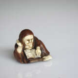 Netsuke des Daruma ein Buch lesend mit Hossu-Wedel aus Holz teils mit Elfenbein und Horn eingelegt - photo 2