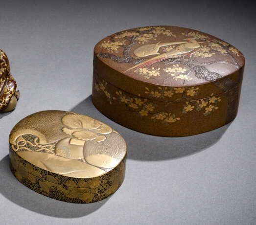 Zwei Deckeldosen aus Lack mit Goldlackdekor von Attributen der Glücksgötter bzw, ein Paar Fasane im Geäst eines Prunus - Foto 1