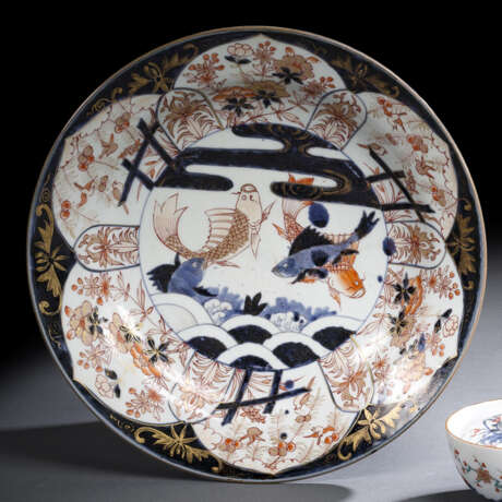 Teller aus Porzellan mit Dekor von Koi-Karpfen in einem Teich umgeben von floralen Motiven in den Farben der Imari-Palette - photo 1