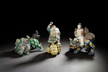 Drei Kutani-Porzellan Gruppen: Daikoku, Paar balgende Shishi und Monju Bosatsu auf einem Shishi reitend