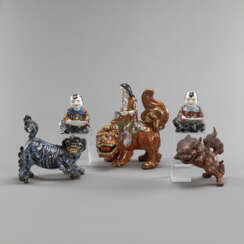 Gruppe von fünf Porzellan-/Keramikteilen: Monju Bosatsu auf Löwe, Paar Knaben und zwei Löwen