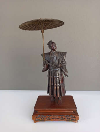 Bronze eines Höflings im Schatten seines aufgespannten Schirm s seinen Blick in die Ferne schweifend lassen - photo 2