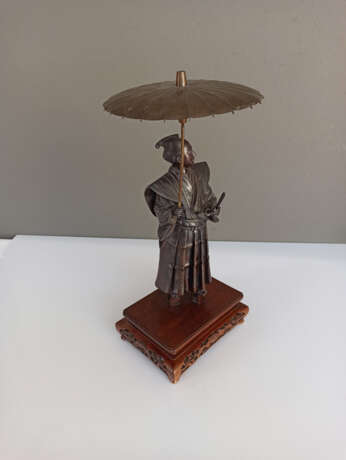 Bronze eines Höflings im Schatten seines aufgespannten Schirm s seinen Blick in die Ferne schweifend lassen - photo 3