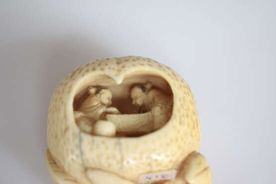 Drei Netsuke aus Elfenbein bzw. Holz: Manju mit Dekor einer Libelle und Lotusblättern, Miniatur einer achitektonischen Anlage und großer Pfirsich im Innern mit zwei Brettspielern an einem Tisch - photo 10