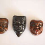 Drei Masken-Netsuke von Hyottoko, Okina und eines Greisen aus verschiedenen Hölzern, teilweise lackiert - Foto 2