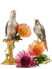 Two fully sculptured silver parrots on stand