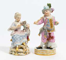 Porcelain figurines of boy with stick horse and lady feeding kitten