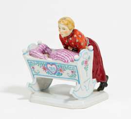 Porcelain figurine of girl with cradle