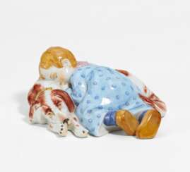 Porcelain figurine of child lying on dog