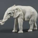 Porzellanfigur ''Elefant'' Karl Ens, Volkstedt, nach 1919, Porzellan, glasiert, mit dezenter Unterglasurmalerei versehen, naturalistische Ausformung eines afrikanischen Elefanten, bodenseitig unterglasurgrüne Mühlenmarke, HxB: ca - Foto 1