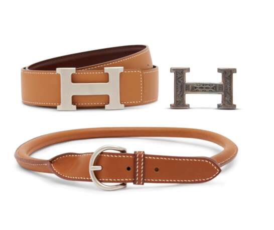 A SET OF THREE: A BRUSHED SILVER H CLASP WITH REVERSIBLE GOLD AND CHOCOLATE LEATHER BELT, A NATURAL BARENIA LEATHER BELT & A STERLING SILVER TOUAREG CLASP - Foto 1