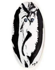 Large oval underglazed ceramic in black and blue on a white background, decorated with an anthropomorphic face