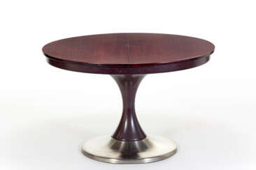 Dark wood dining table with extendable circular top, turned central support and metal coated base