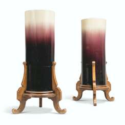 A PAIR OF AUBERGINE AND CREAM GLAZED EARTHENWARE CYLINDRICAL VASES AND STANDS
