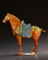 A VERY WELL-MODELED BLUE AND SANCAI-GLAZED POTTERY FIGURE OF A CAPARISONED HORSE