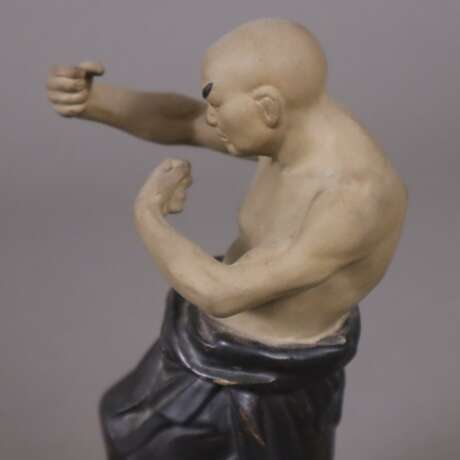Chinesischer Boxer- Figur aus Biskuitporzellan, polychrom staffiert, Boxer in Kampfpose auf einer gekantet ovalen Plinthe stehend, im Boden signiert, H.ca.19,5 cm, China - photo 4
