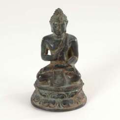 Kleiner Buddha mit segnendem Gestus.