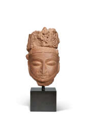 A RED SANDSTONE HEAD OF A DIVINITY