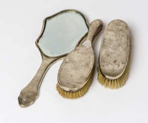 A HAND MIRROR WITH 2 BRUSHES