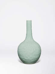 A VERY RARE AND FINELY CARVED CELADON-GLAZED ‘DRAGON’ BOTTLE VASE