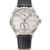 PATEK PHILIPPE. AN ATTRACTIVE 18K WHITE GOLD AUTOMATIC ANNUAL CALENDAR WRISTWATCH WITH REGULATOR-STYLE DIAL, CERTIFICATE OF ORIGIN AND BOX - photo 1
