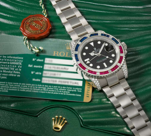 ROLEX. A RARE AND ATTRACTIVE 18K WHITE GOLD, DIAMOND, RUBY AND SAPPHIRE-SET AUTOMATIC DUAL TIME WRISTWATCH WITH SWEEP CENTRE SECONDS, DATE, BRACELET, GUARANTEE AND BOX - Foto 2