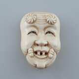 Kleine Nō-Maske / Okimono- Elfenbein fein geschnitzt und graviert, Nō-Maske vom Typ Okina (Darstellung des „lächelnden alten Mannes“), ca. 2,4 x 3 cm, ca.12,8 g, Japan, ca. Taishō-/ frühe Shōwa-Zeit - Foto 1