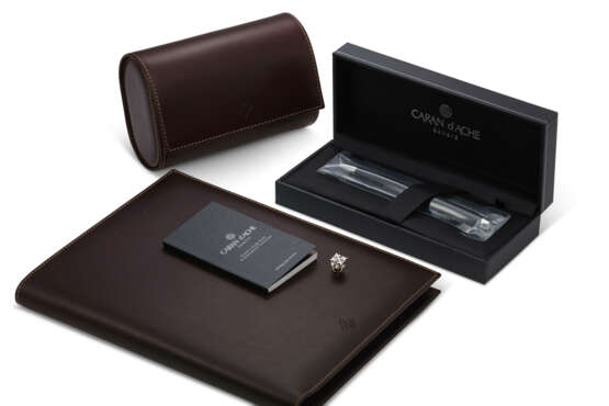 PATEK PHILIPPE, A LEATHER TRAVEL CASE, PEN NOTEBOOK AND LAPEL PIN - Foto 1