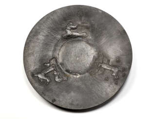 Pewter plate decorated with embossed reliefs depicting scenes from the life of St. Francis. Italy, 1930s/1940s. (d 49 cm.)