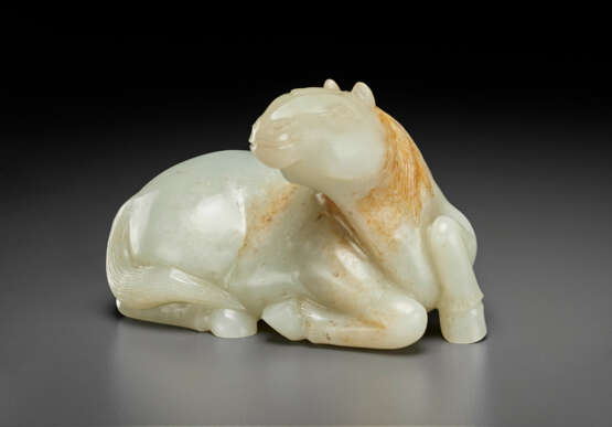 A WHITE AND RUSSET JADE FIGURE OF A RECUMBENT HORSE - photo 1
