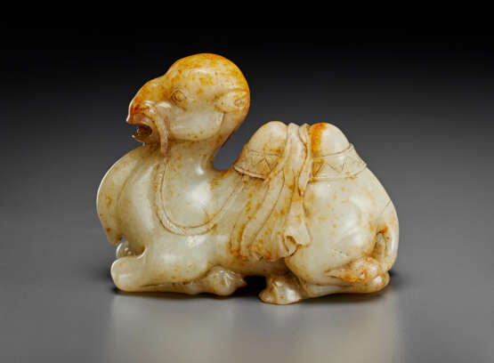 A FINELY CARVED PALE GREY AND RUSSET JADE FIGURE OF A RECUMBENT CAMEL - фото 1