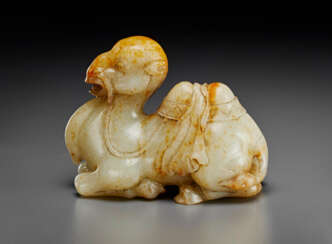 A FINELY CARVED PALE GREY AND RUSSET JADE FIGURE OF A RECUMBENT CAMEL