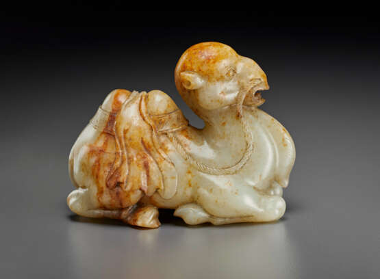 A FINELY CARVED PALE GREY AND RUSSET JADE FIGURE OF A RECUMBENT CAMEL - Foto 2
