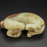 A PALE BEIGE AND RUSSET JADE FIGURE OF A RECUMBENT HORSE - фото 1