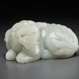 A FINELY CARVED PALE GREYISH-WHITE JADE FIGURE OF A RECUMBENT MYTHICAL BEAST - photo 4
