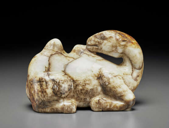 A MOTTLED GREY, BLACK AND RUSSET JADE FIGURE OF A RECUMBENT CAMEL - фото 1
