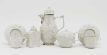 A coffee pot, teapot, tea caddy and two cups with saucers