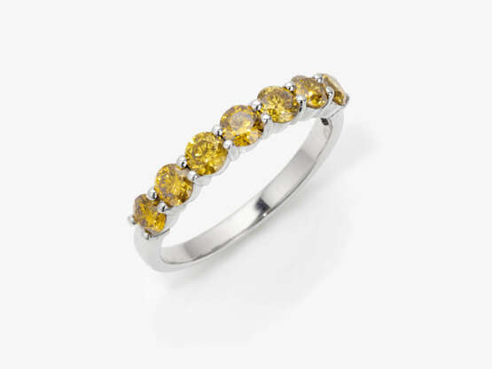 An eternity ring decorated with natural fancy vivid yellow brilliant cut diamonds - фото 1
